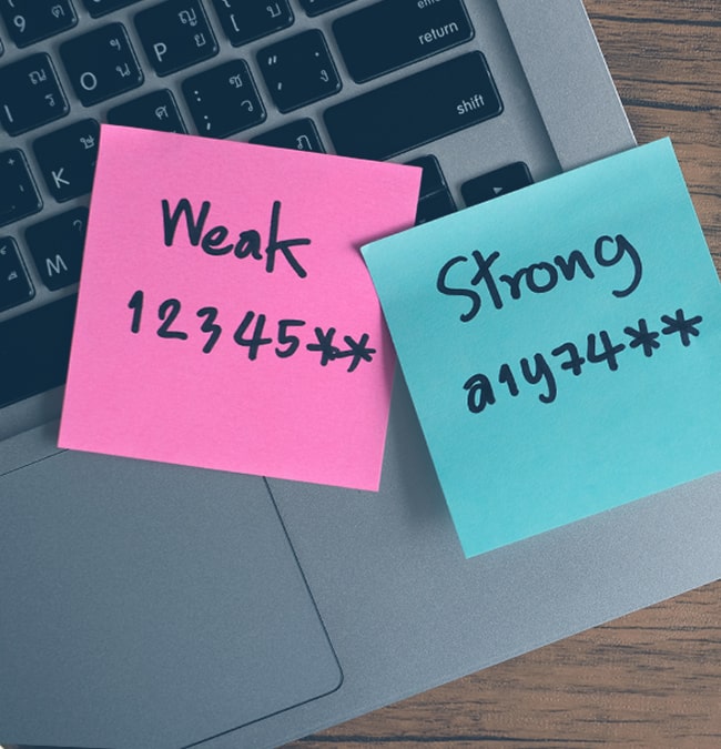 Closeup of two post-it notes on a laptop with passwords written on them