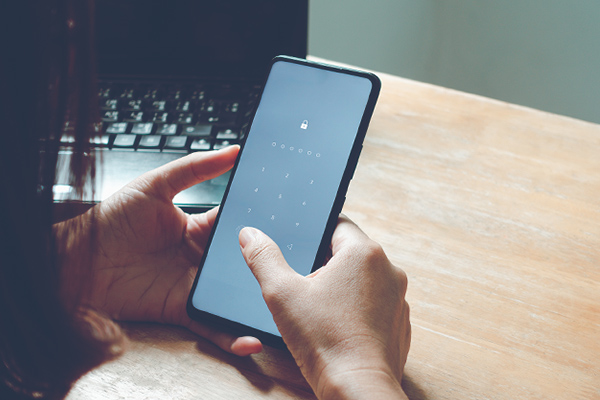 Hands typing in password on smartphone
