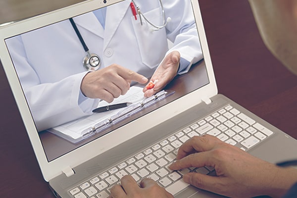 Doctor on laptop screen doing telehealth visit