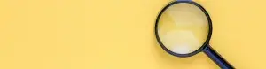 Magnifying glass on yellow backdrop